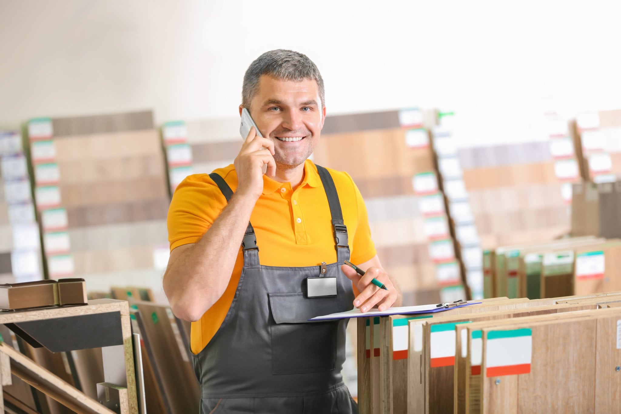 Carpenter talking on phone in hardware store Carpenter talking on phone in hardware store